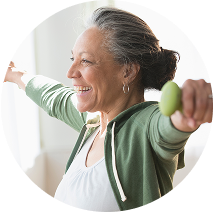 Older woman smiling while she works out with dumbbells
