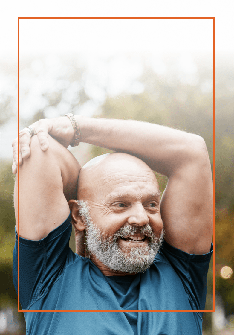 Older man in a blue shirt stretching outside