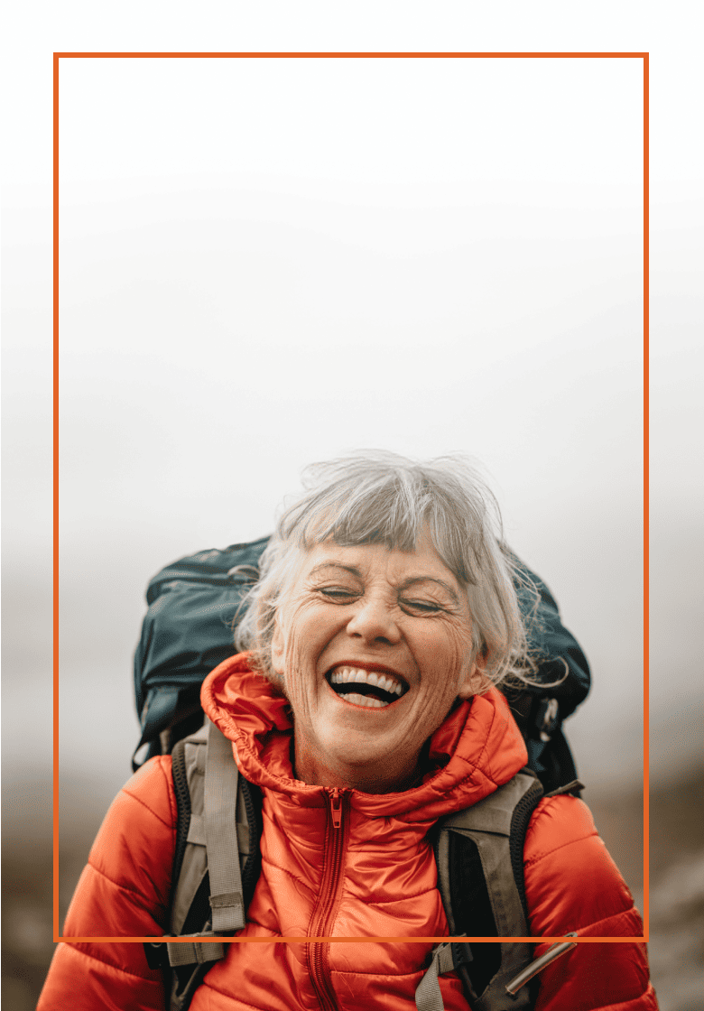 Older woman laughing as she hikes