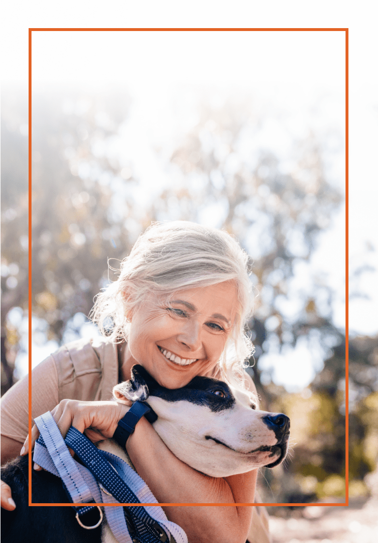 Older woman smiling as she holds her dog