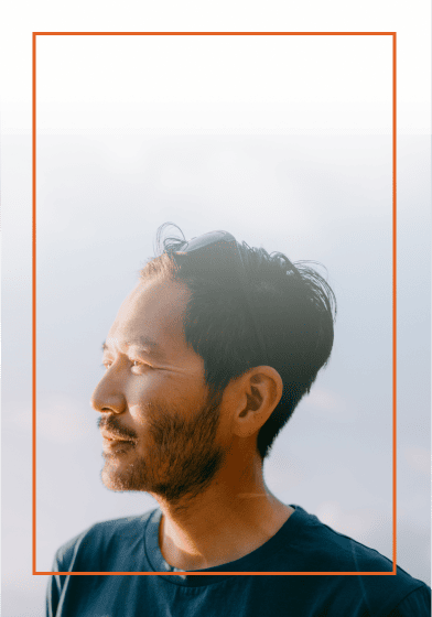Adult man looking off into in the left with the sun behind him