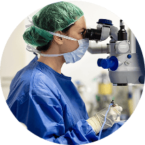 Doctor in scrubs looking into a large machine