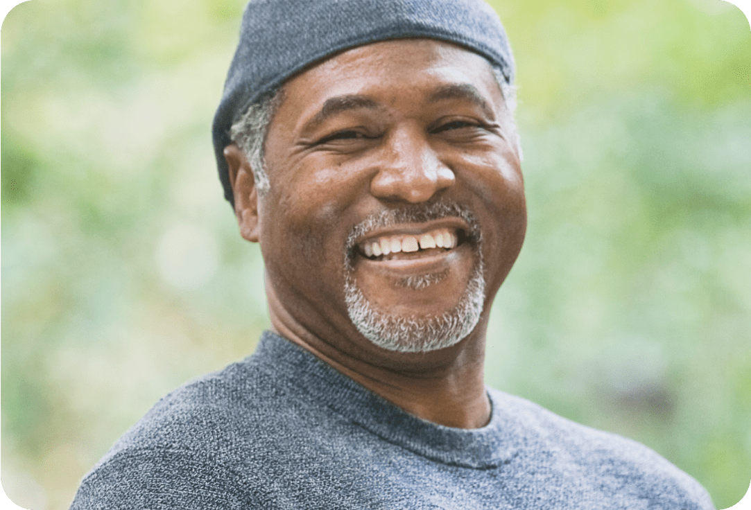 Older man in a hat smiling