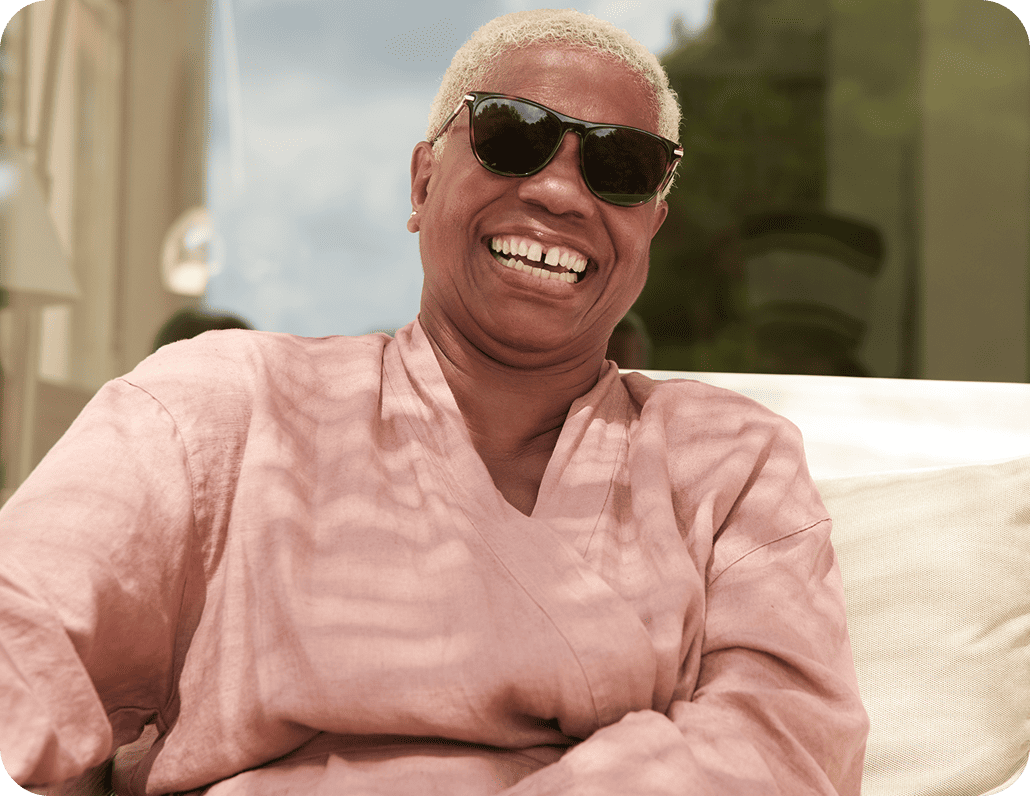 Elderly man sitting on a couch while he is smiling
