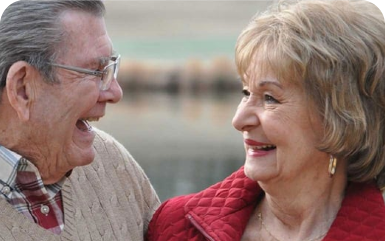 Elderly couple smiling at each other