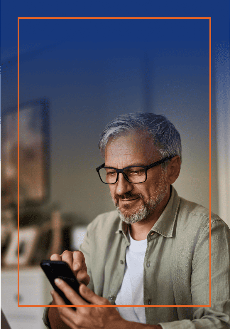 Older man sitting on a couch with a tablet in hand