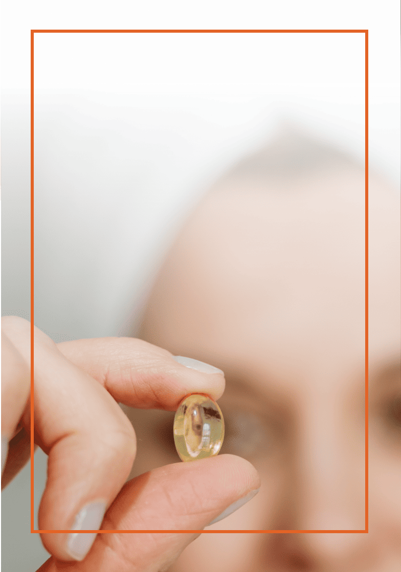 Close up of an older individual holding a pill
