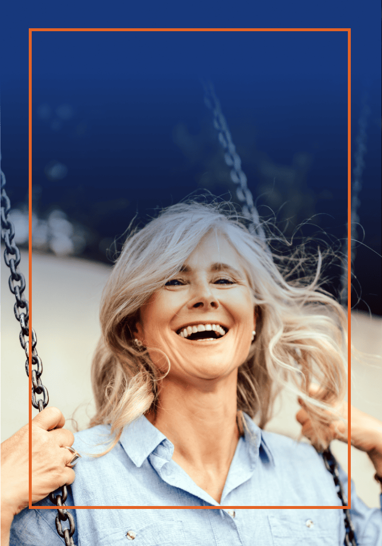 Blond woman smiling as she swings on a swing