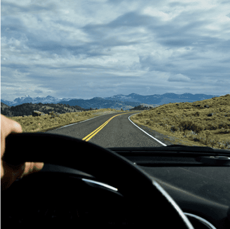 Point of view photo of someone driving a car down a scenic road