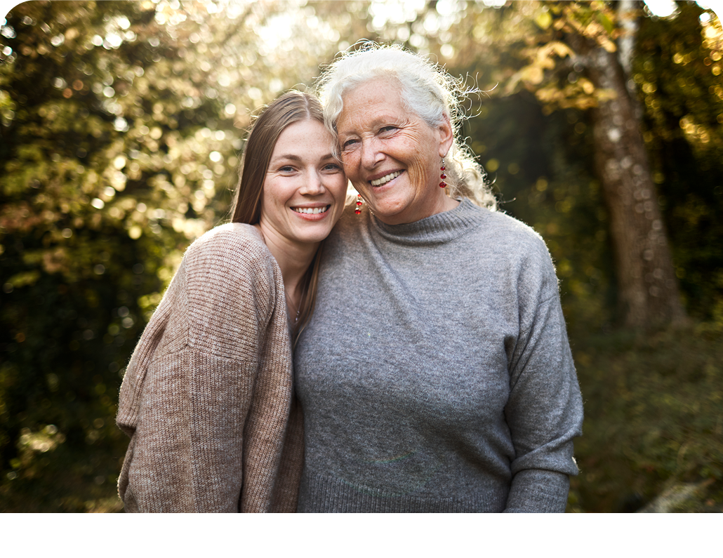 Grandmother and granddaughter standing next to each other while smiling