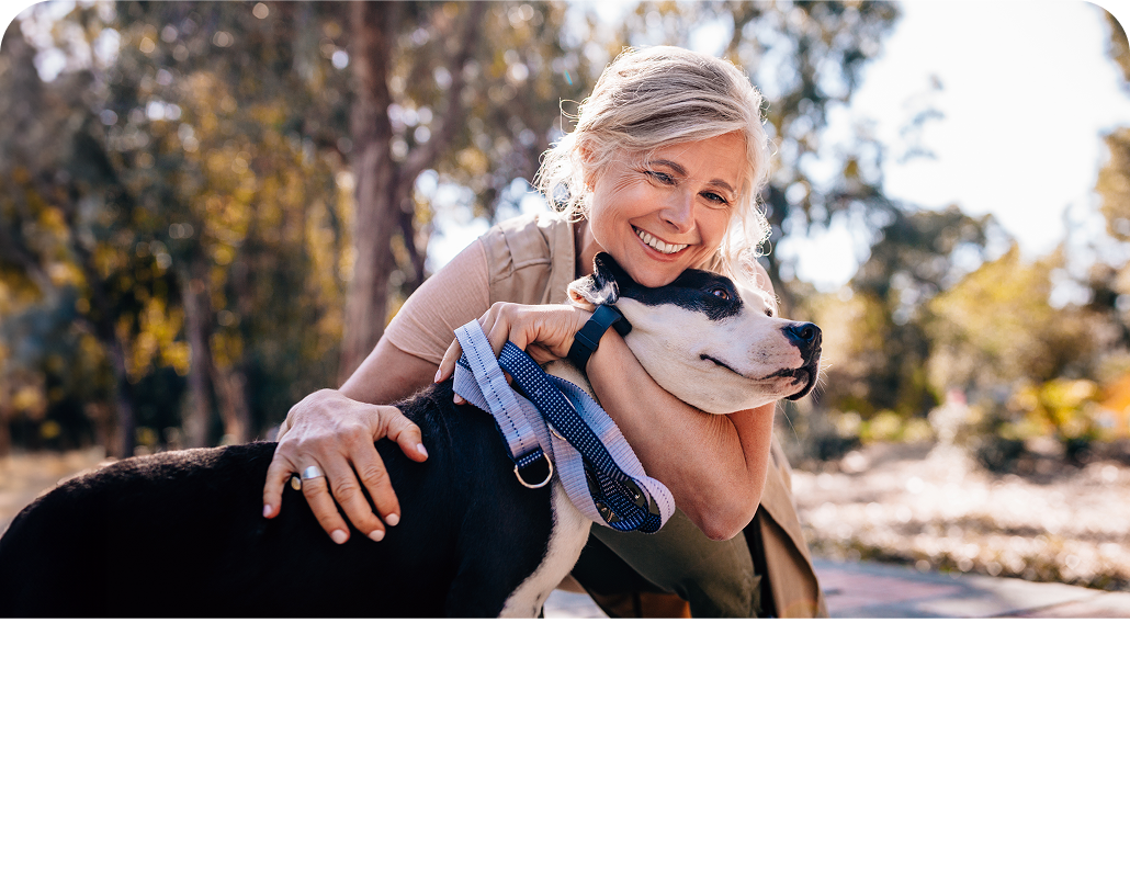 Woman holding her dog while she is smiling