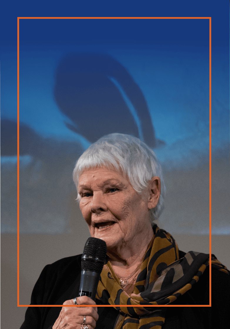Judi Dench holding a microphone