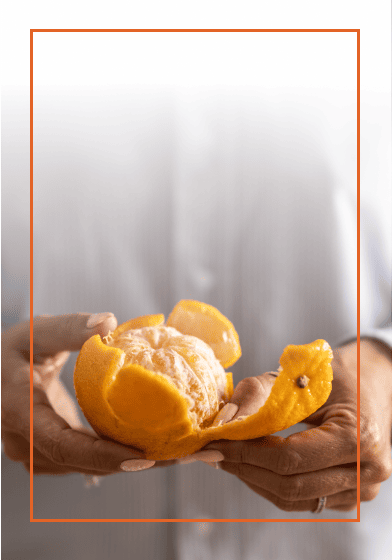 Close up of someone pealing an orange
